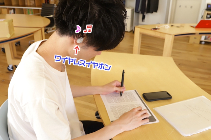 [ワイヤレスイヤホンを付けて作業している写真]