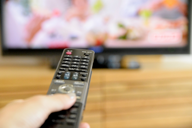 テレビのリモコンを操作している写真