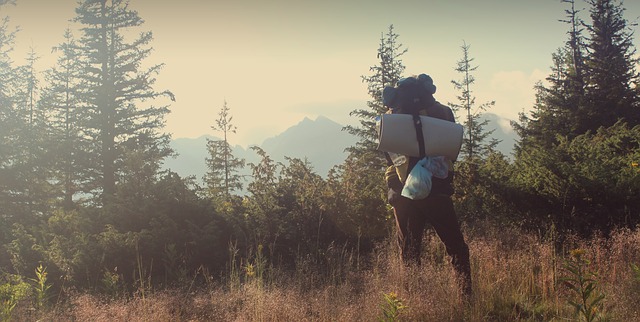 寝袋を持って登山している人の写真