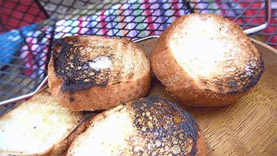 焼いたバケットにバターとオリーブオイルを塗る様子