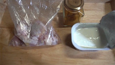 鶏肉にヨーグルトとカレー粉をもみ込む様子