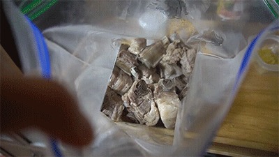 スペアリブに焼き肉のたれとにんにくを加える様子