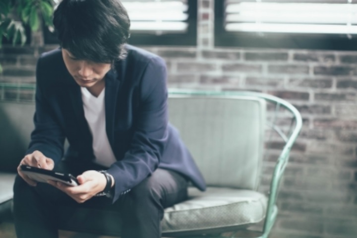 男性がiPadを操作している画像