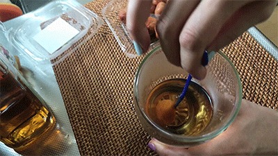 ウイスキーのお湯割りに入れた梅干しを潰す様子