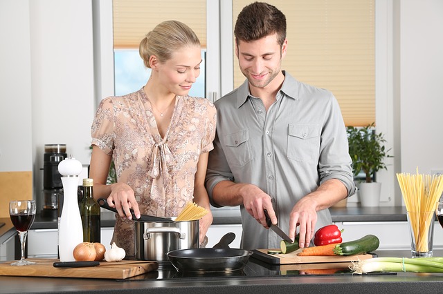 二人で料理をする男女の画像