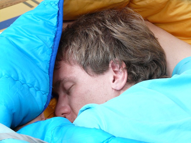 シュラフで眠る男性