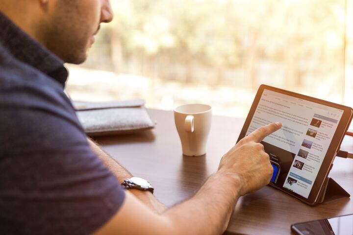 テーブルに置いたiPadを操作する男性