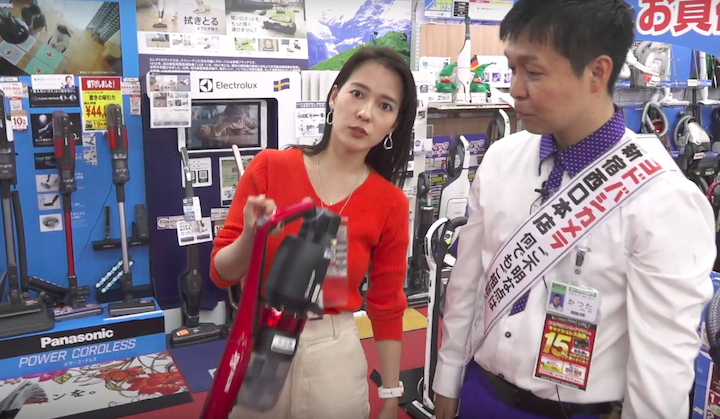 シャープの掃除機「RACTIVE Air」を人差し指で持ち上げる奈津子画像