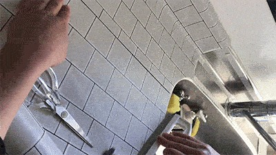 キッチンのワークトップにリメイクシートを貼ってヨレを伸ばす様子