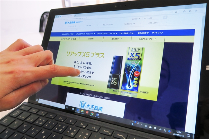 発毛剤の公式サイトを指差す毛髪診断士の鎌田さん