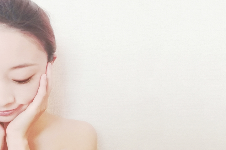 頬に手を当てる女性の写真