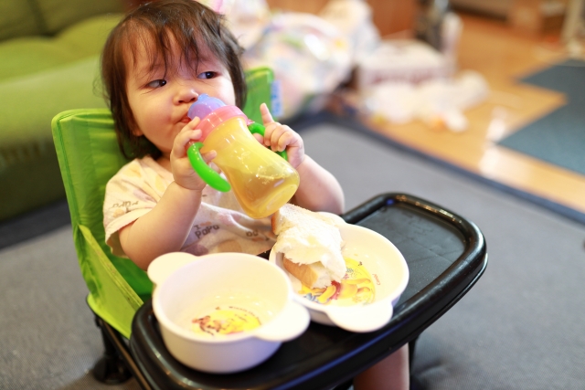 ベビーチェアで食事をする赤ちゃん