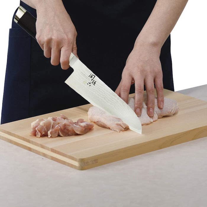三徳包丁で肉を切る男性