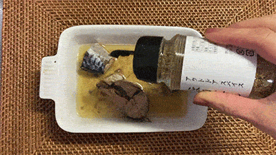 レンジでチンしたサバ缶にほりにしを振りかけている様子