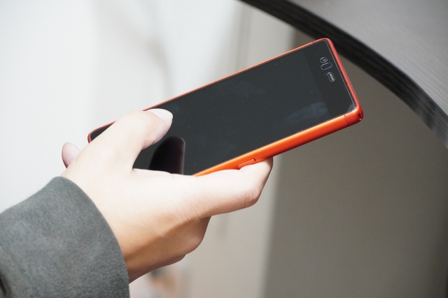 右手にスマートフォン