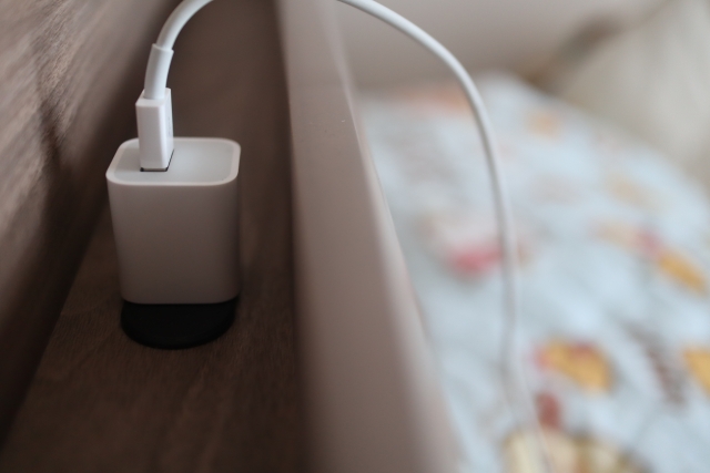 ベッドのコンセントに充電器を差し込んでいる画像