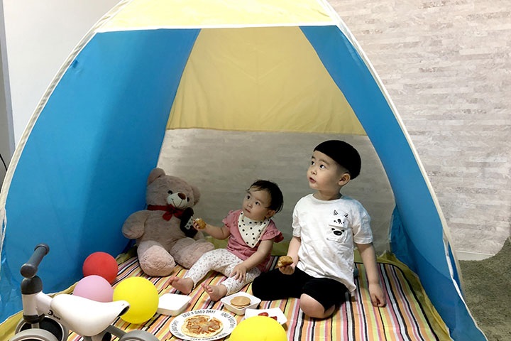テントでお家キャンプを楽しむ子供