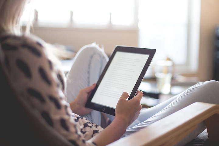 タブレットで電子書籍を読む女性の写真