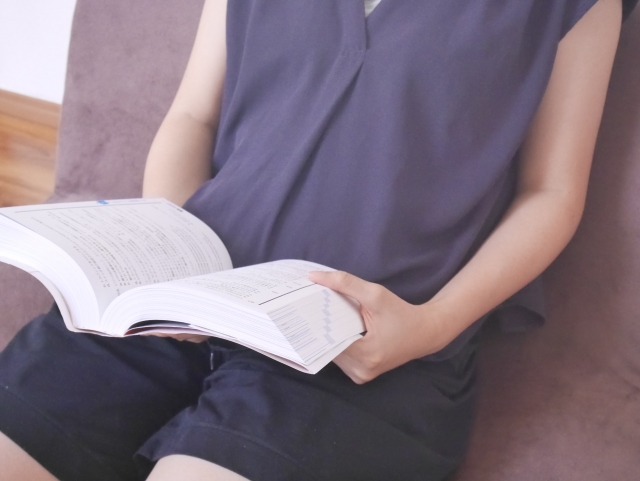 座椅子に座って読書を楽しむ女性の写真