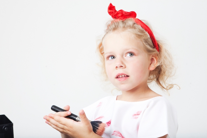 メイクブラシを持つ女の子の写真