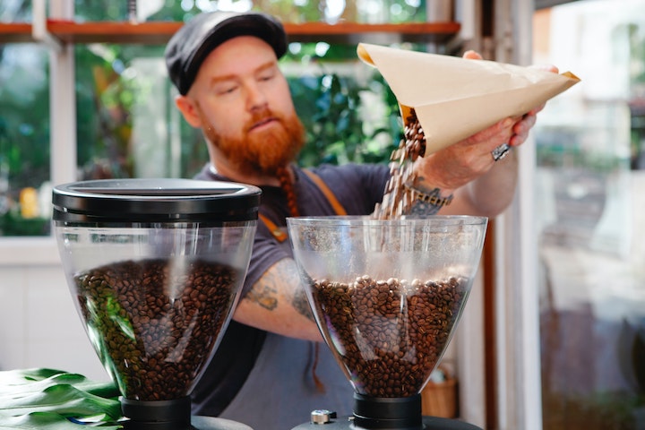 ミルにコーヒー豆を入れる外国人男性