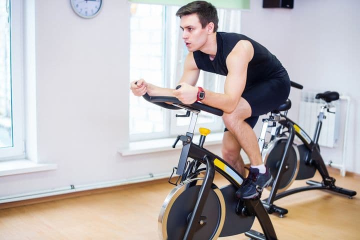 男性がスピンバイクに乗っている写真