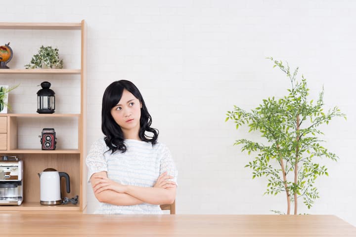 リビングで考え事をする女性の写真