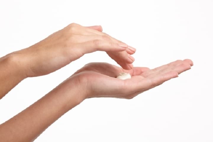 クリームを手に取る女性の手元