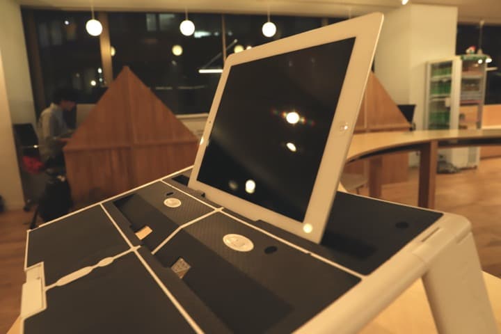 [上の窪にいタブレットを設置しているところ]