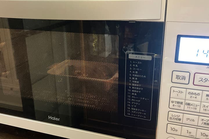 耐熱容器に入ったサバ缶をレンジで温めている様子
