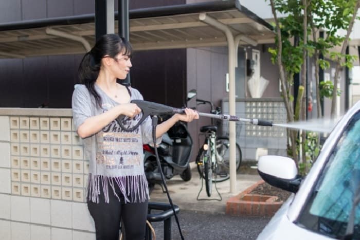 高圧洗浄機を使用する女性の写真