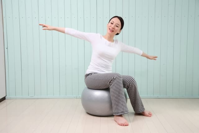バランスボールでトレーニングする女性の画像
