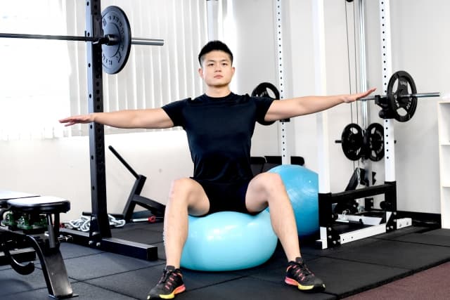 バランスボールに座る男性の画像