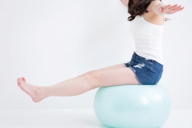バランスボールを使ってトレーニングする女性の画像