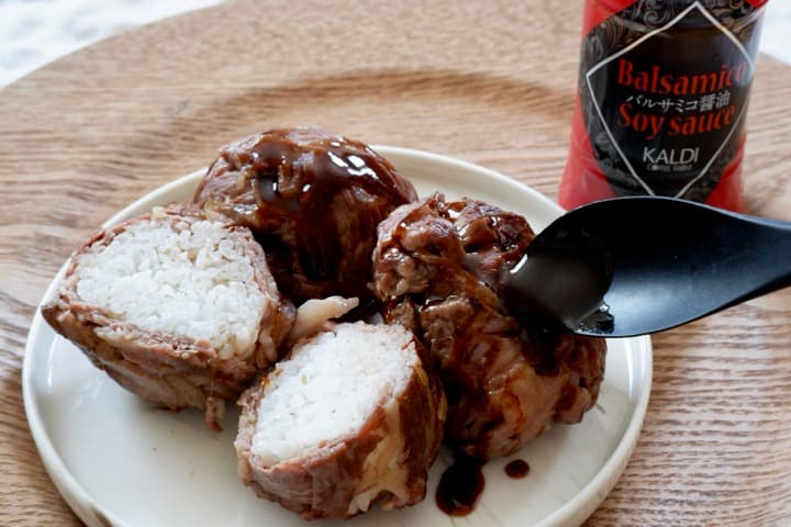 肉巻きおにぎりにソースをかけている画像