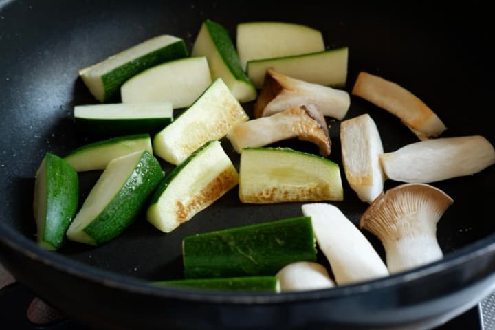 ズッキーニとエリンギをフライパンで焼いている画像