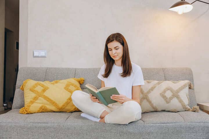 リビングで本を読む女性