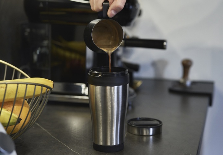 蓋付きタンブラーにコーヒーを注ぐ