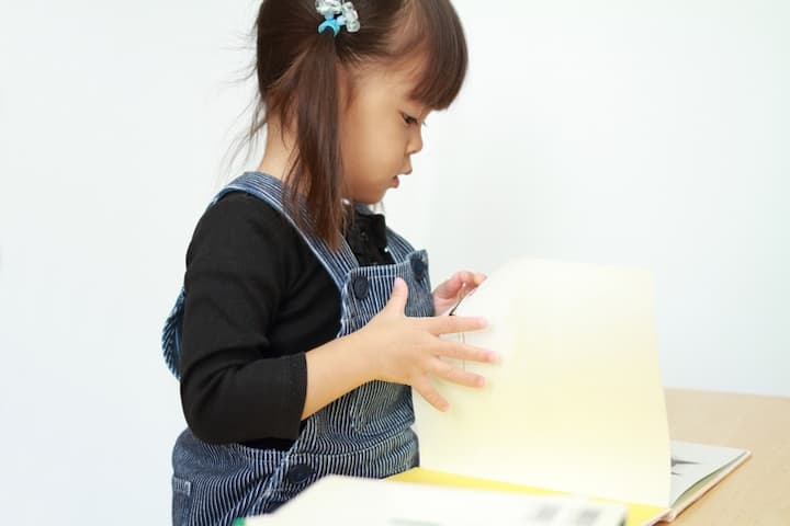 子供がキッズデスクで絵本を読むイメージ