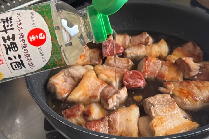 豚肉に日の出料理酒 醇良をかける様子