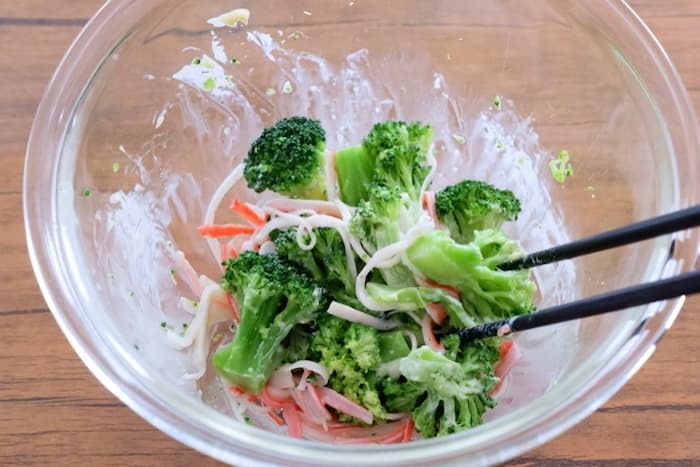 ブロッコリーとカニカマを入れて和える様子