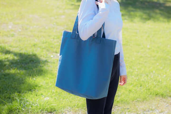 アウトドアでトートバッグを使う女性