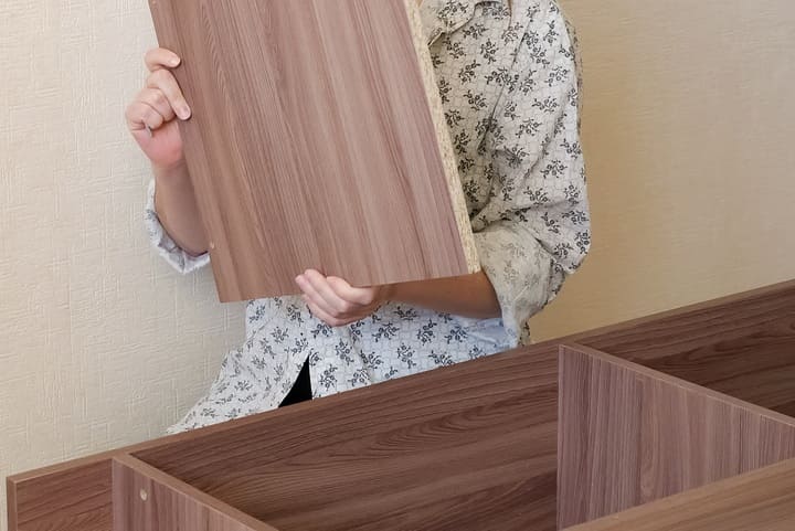 棚板を取り付けている女性